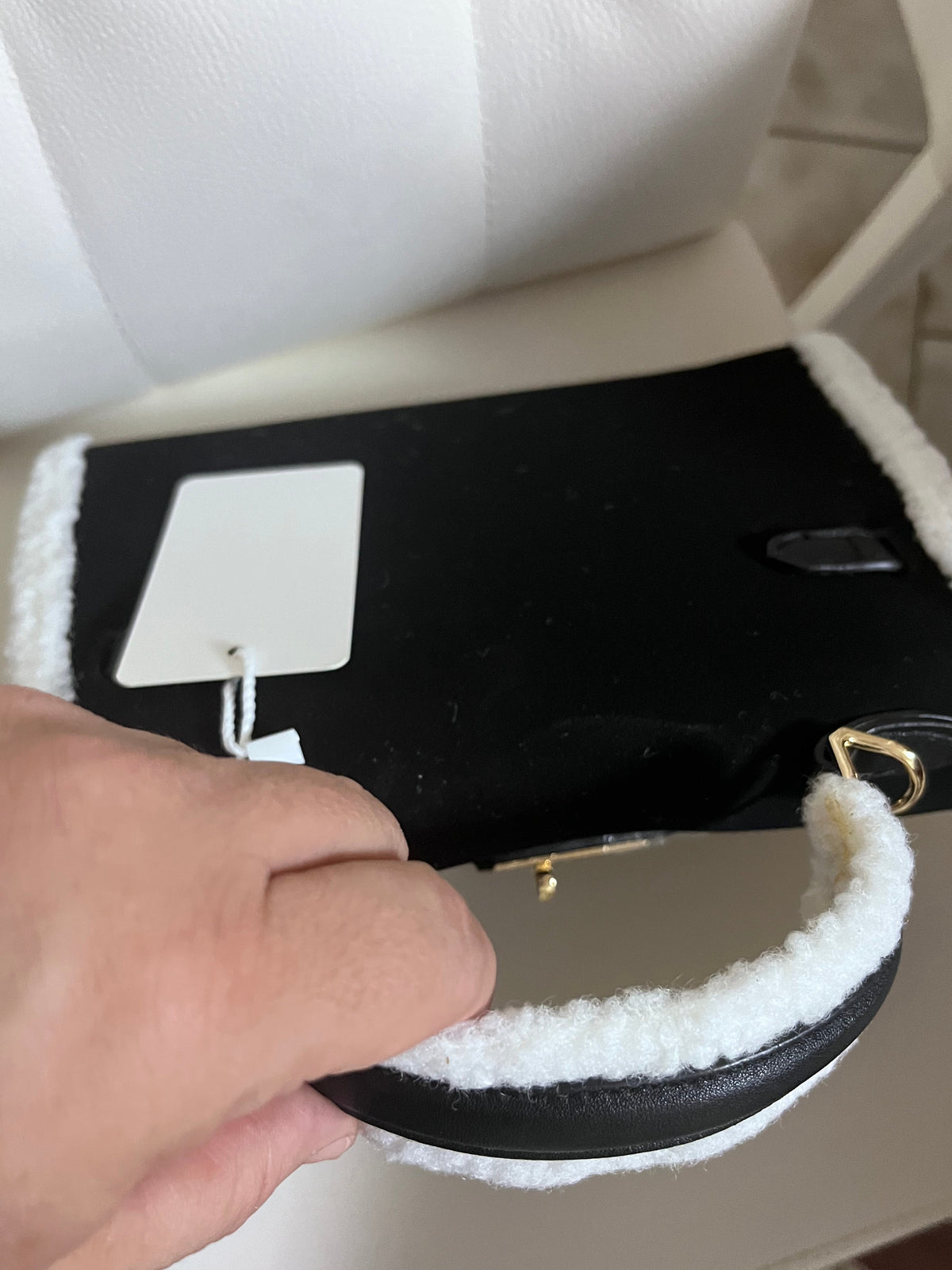 Dettaglio manico shearling bianco e anello dorato