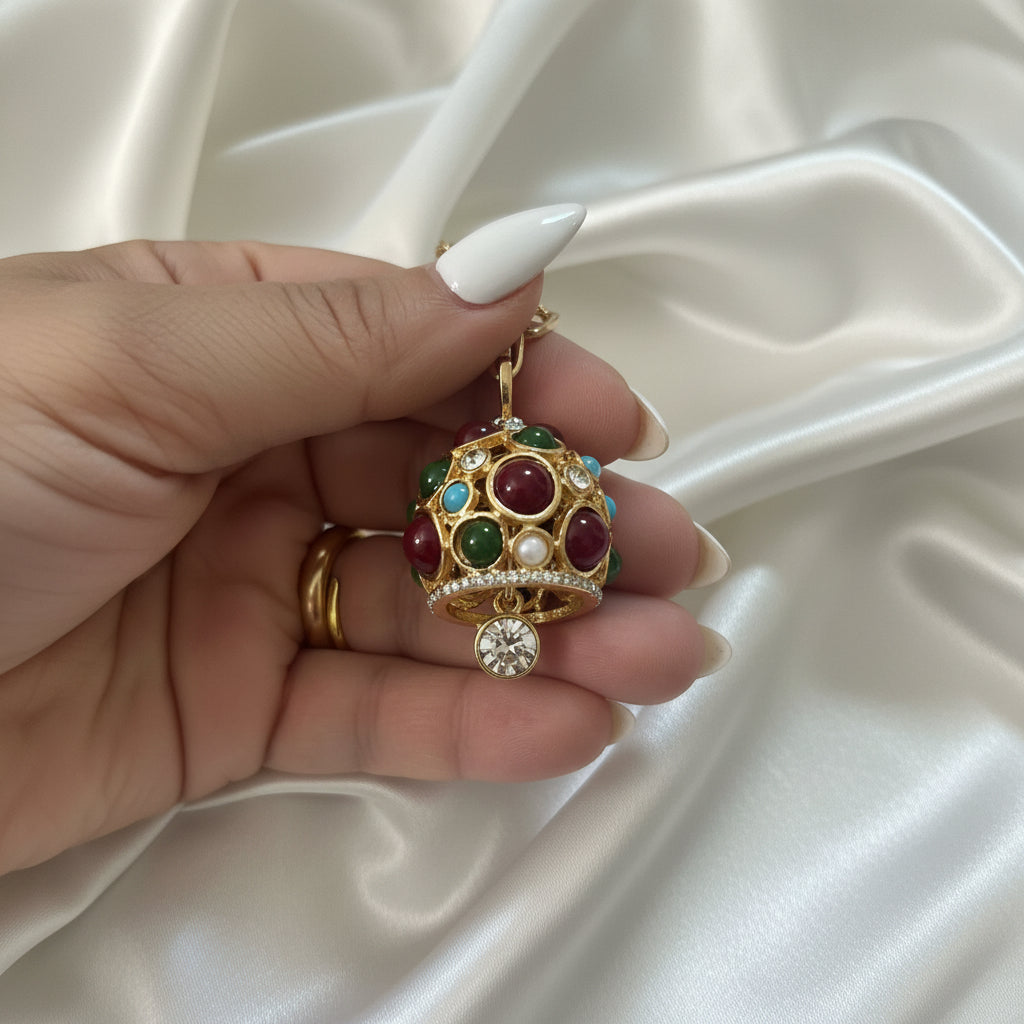 Dettaglio della collana lunga dorata con pendente multicolore