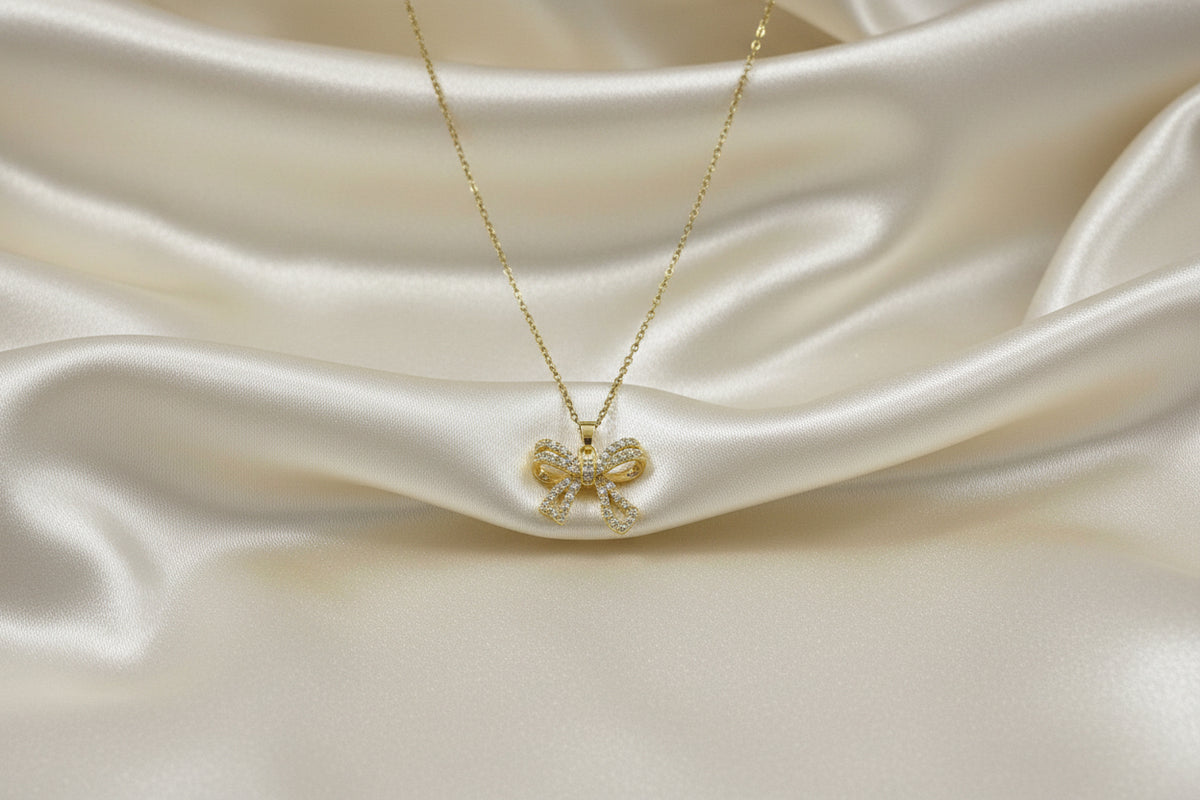 Collana color argento con pendente a fiocco dorato