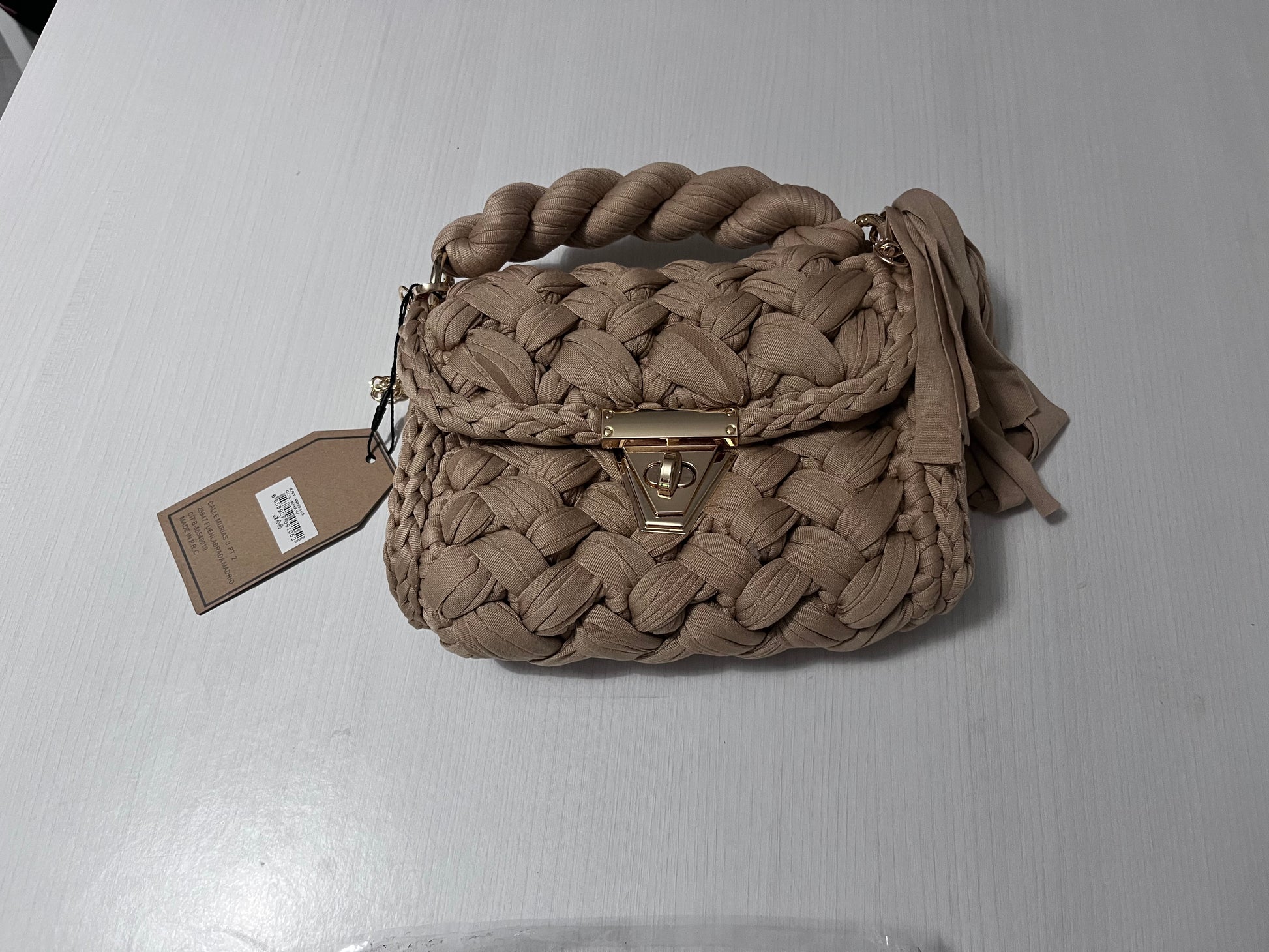 Borsa a mano in corda intrecciata beige con manico ritorto e chiusura dorata - vista frontale