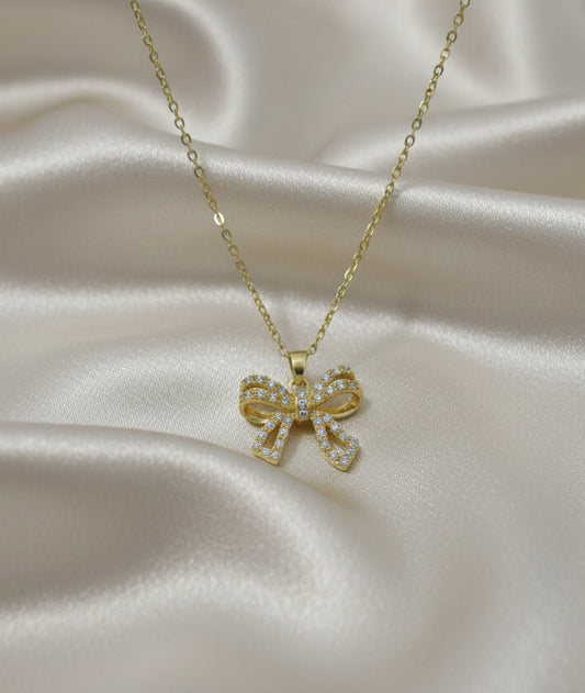 Dettaglio della collana color argento con pendente a fiocco dorato