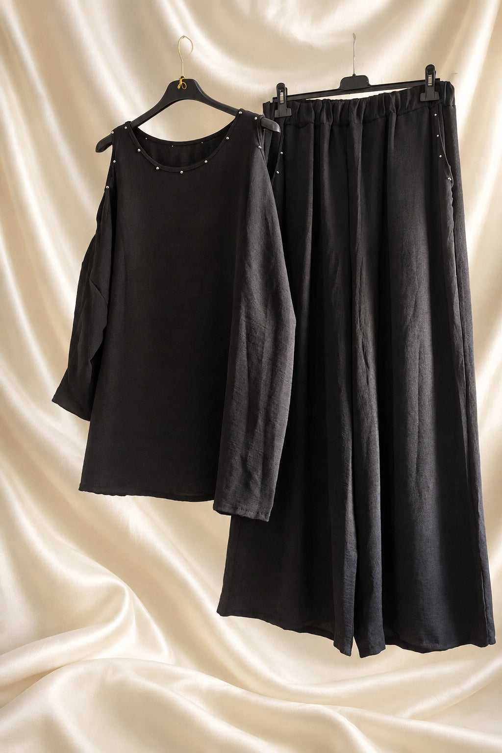 Completo nero con blusa e pantaloni ampi con dettagli luminosi