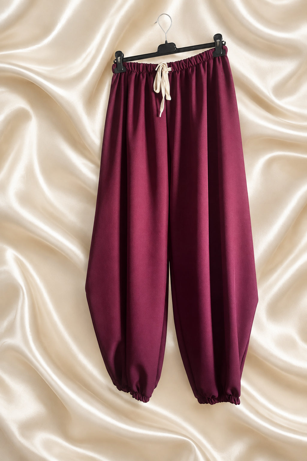Pantaloni bordeaux con vita elasticizzata, laccio chiaro e fondo arricciato