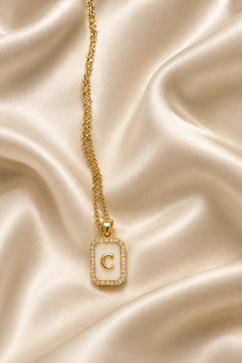 Collana dorata con ciondolo rettangolare e iniziale C