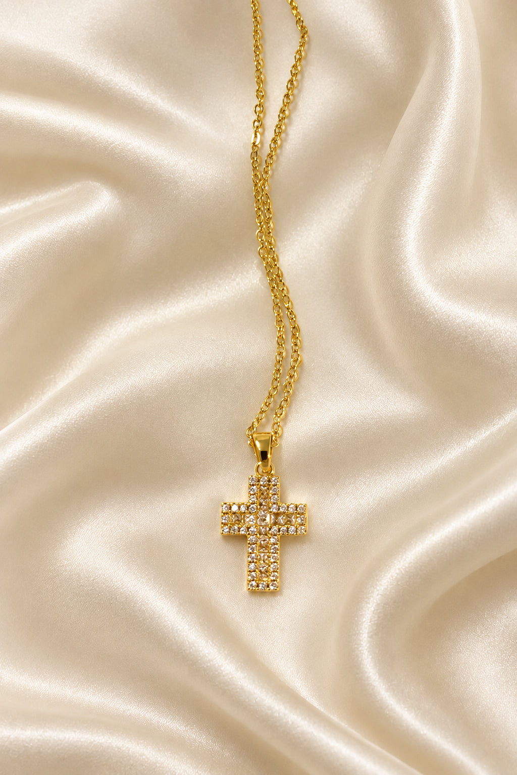 Collana dorata con croce chiara e dettagli luminosi