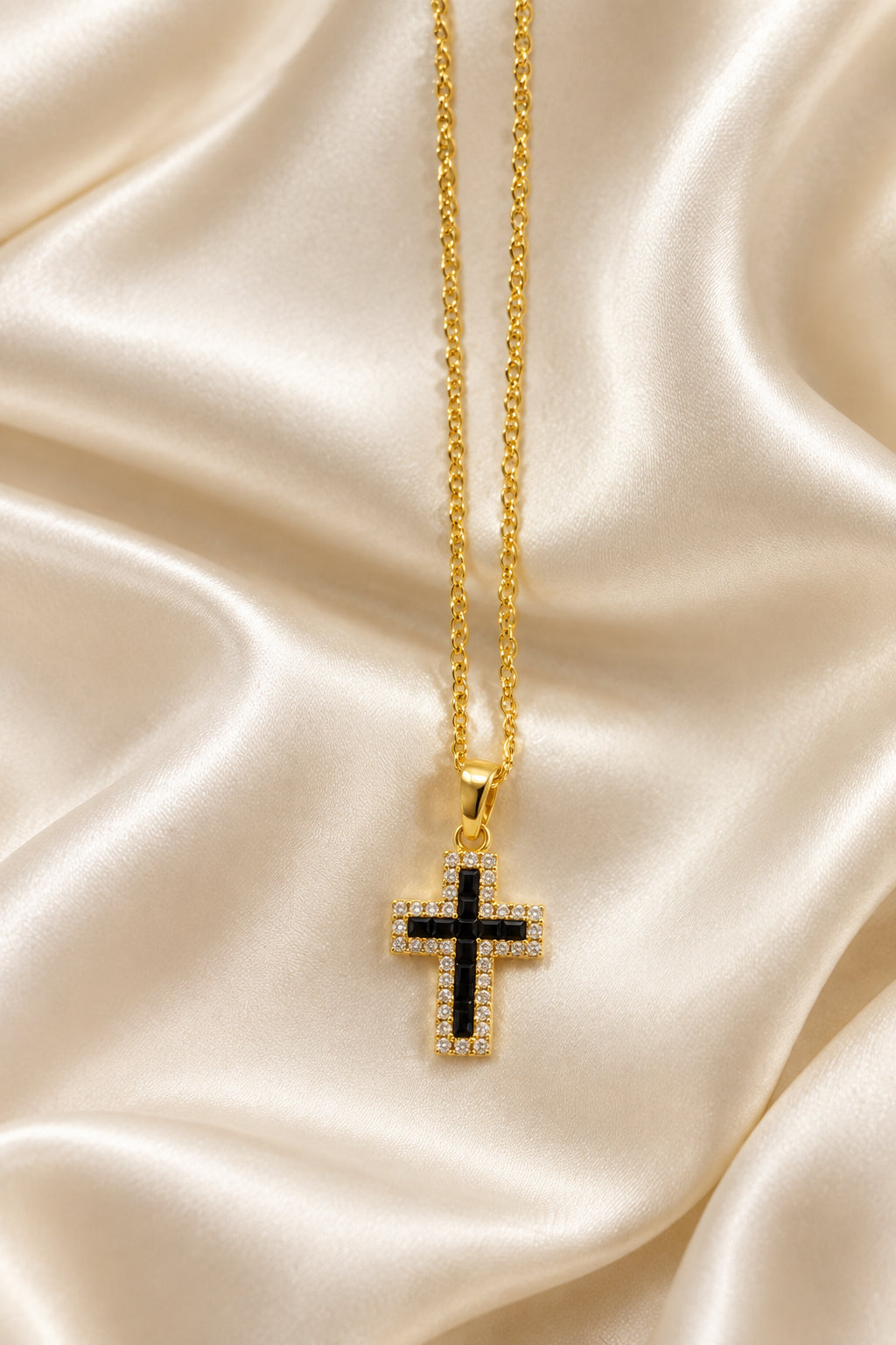 Collana dorata con croce dal centro nero e bordo luminoso